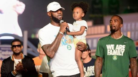 Cleveland Cavaliers' LeBron James speaks while holding his