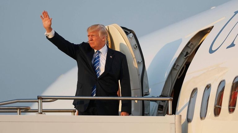 President Donald Trump waves while boarding Air Force