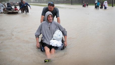 People make their way out of a flooded