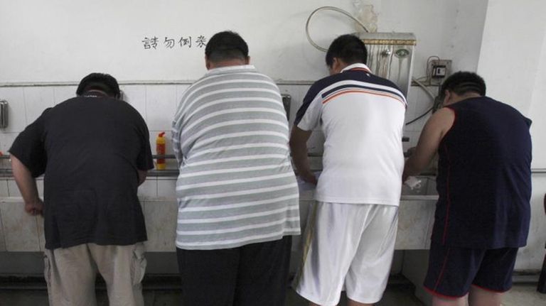 Obese patients wash their plates after lunch at
