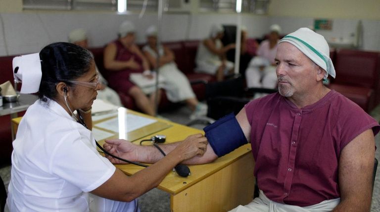 A nurse checks a patient's blood pressure at