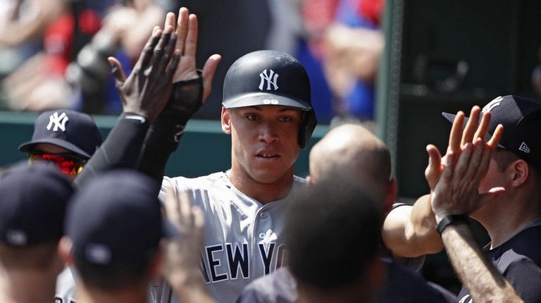 Aaron Judge celebrates with teammates after scoring the