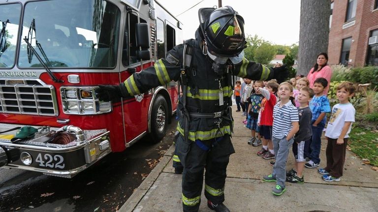 A Lynbrook firefighter displays protective gear to students