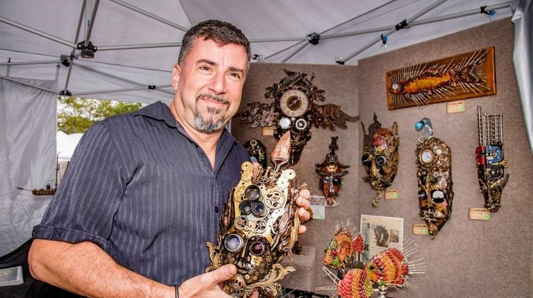 Artist Larry Agnello, holds up one of the
