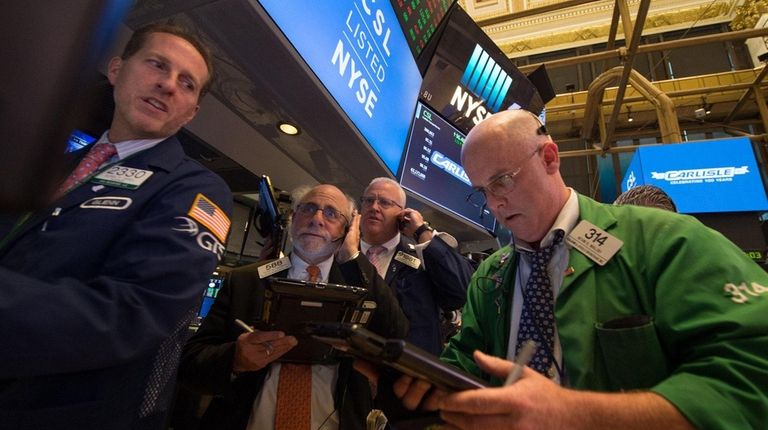 Traders work on the floor at the closing
