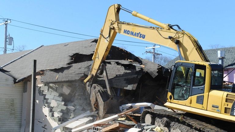 Mastic Beach paramedics look on as the demolition