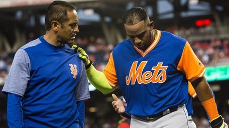 Yoenis Cespedes of the Mets is helped off