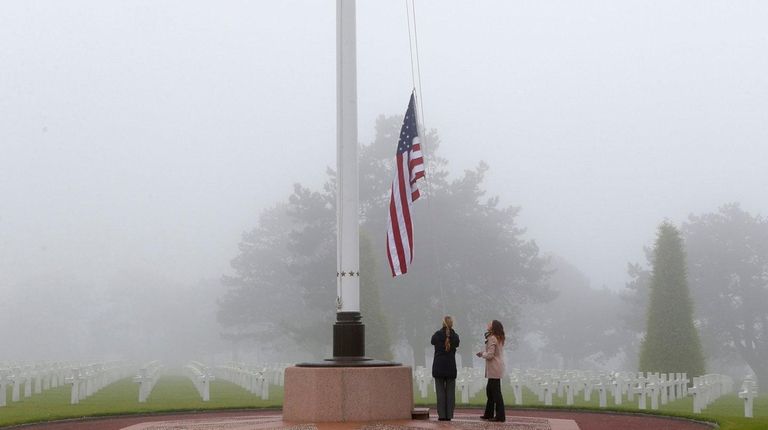U.S. staff members raise the U.S. flag at
