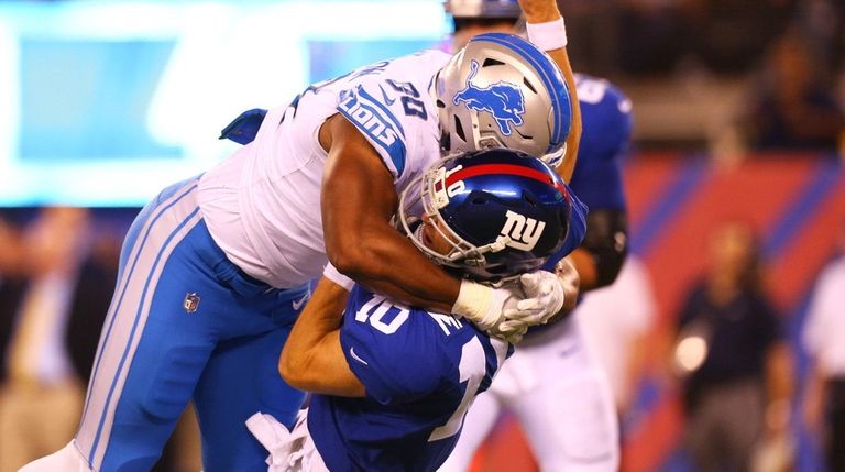 Eli Manning of the Giants is knocked down by