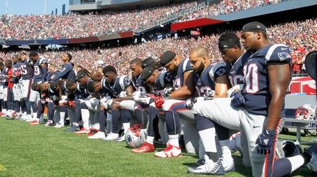 Members of the New England Patriots kneel during