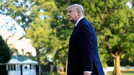 President Donald Trump walks towards the White House
