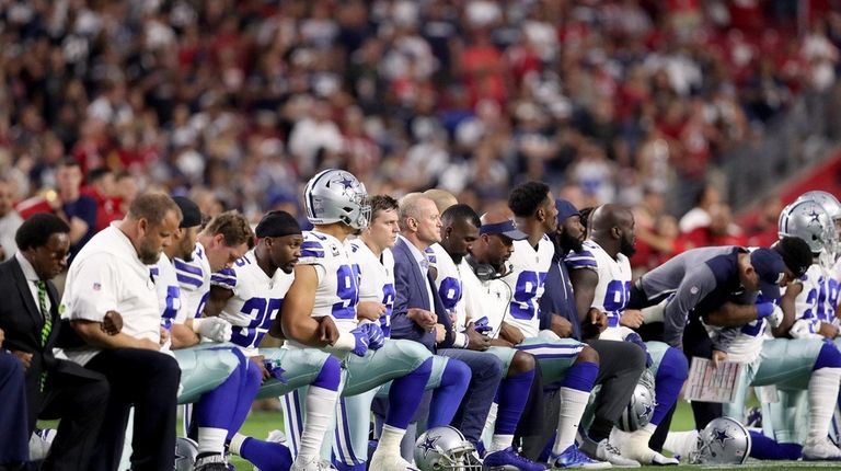 Members of the Dallas Cowboys link arms and