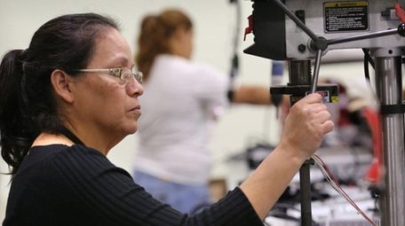 Assembly operator Sonia Ramirez assembles LED lighting fixtures at