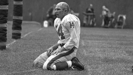 The New York Giants' Y.A. Tittle squats on
