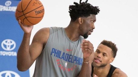 Philadelphia 76ers' Joel Embiid, left, does a post-up