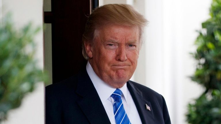 President Donald Trump waits outside the West Wing