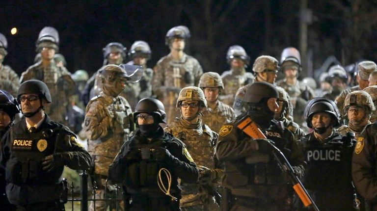 Police and Missouri National Guardsmen stand guard as