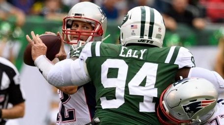 Tom Brady looks to throw as tackle Nate