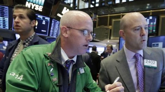 Trader Kevin Walsh, foreground left, works with specialist