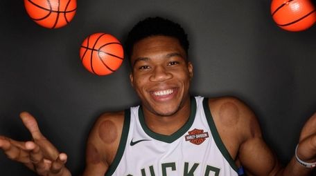 Milwaukee Bucks' Giannis Antetokounmpo juggles some small basketballs