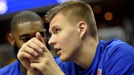 Knicks forward Kristaps Porzingis watches from the bench during