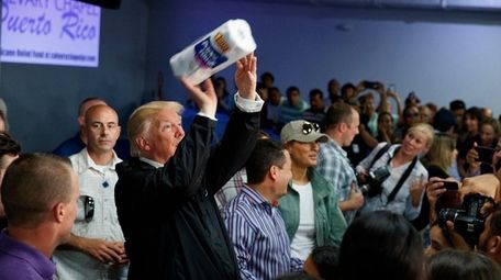 President Donald Trump tosses paper towels into a