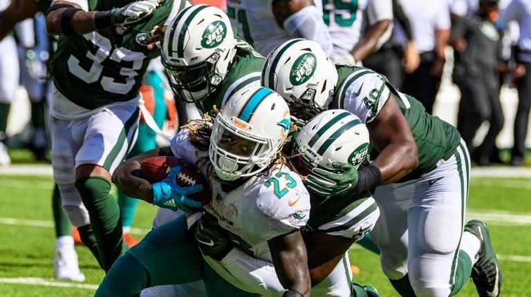 The Jets defense tackles Dolphins running back Jay