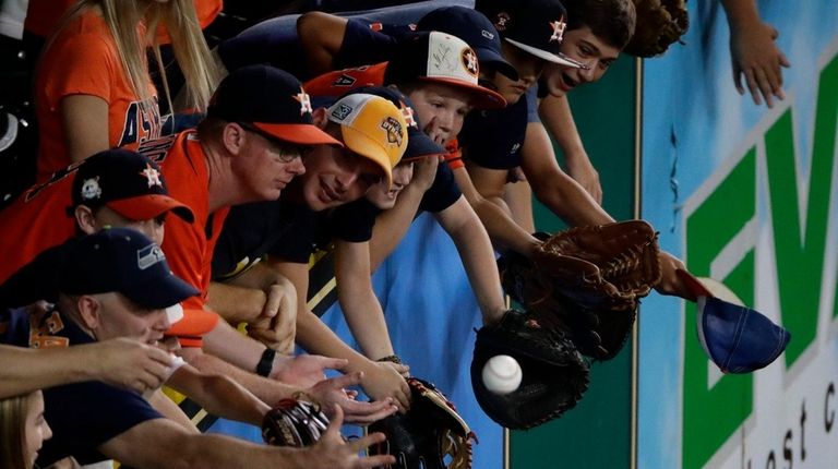 Fans go after a ball hit in the