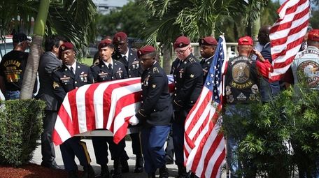 U.S. Military honor guards carry the coffin of