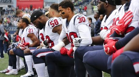 Members of the Houston Texans kneel during