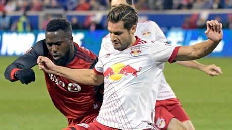 Red Bulls defender Damien Perrinelle holds off Toronto