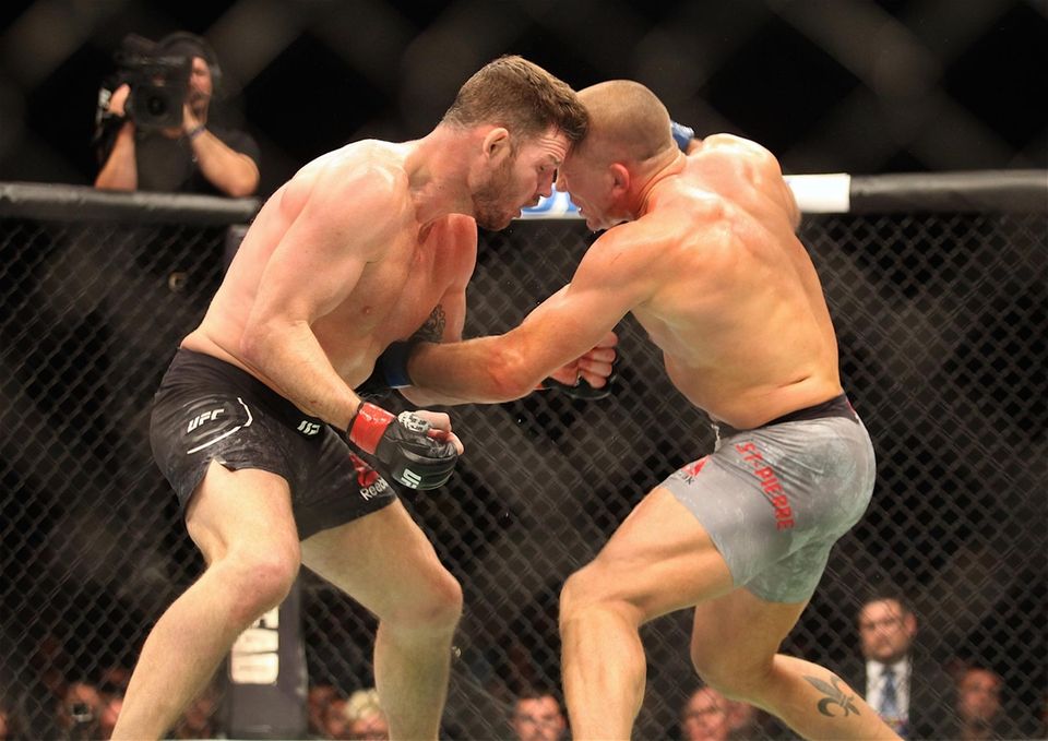 Michael Bisping, left, and Georges St-Pierre exchange strikes