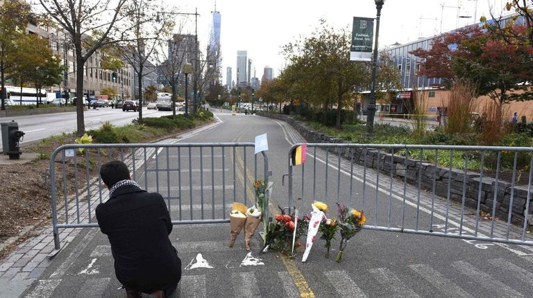 People stop at a memorial Nov. 1, 2017 near