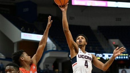 Connecticut's Jalen Adams makes a basket over Stony Brook's