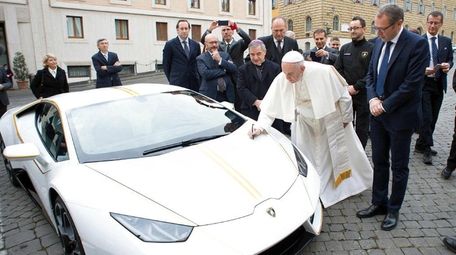 Pope Francis writes on the bonnet of a