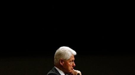Former President Bill Clinton listens during a panel