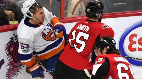 Islanders' Casey Cizikas is checked into the boards