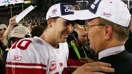 Eli Manning celebrates with co-owner John Mara after