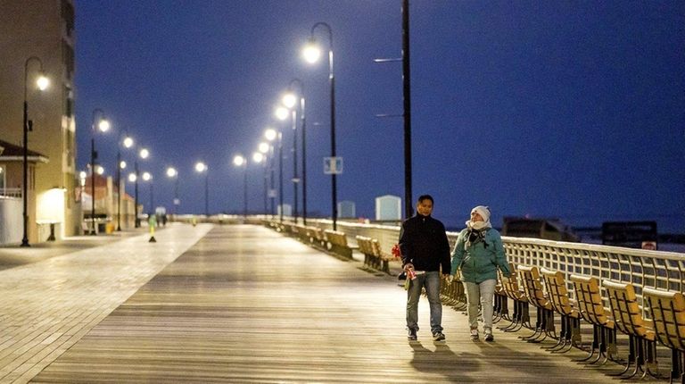 A couple strolls on the boardwalk in Long