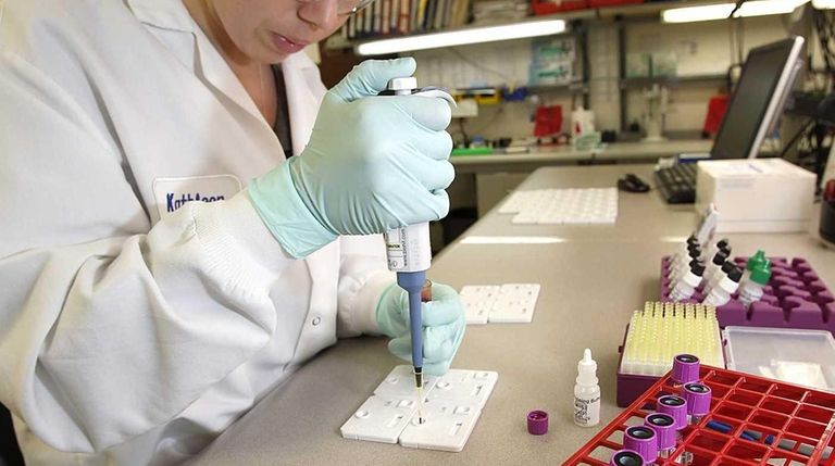 Scientist Kathleen Addiss uses a pipette to introduce