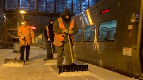 Workers clear snow from the platform at the