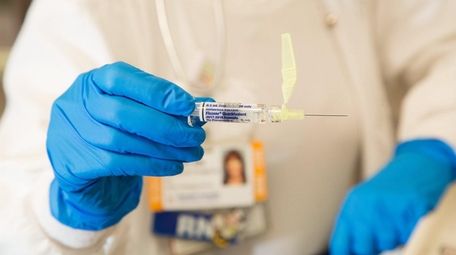 Nurse Eileen Colquhoun-Dougherty handles an influenza vaccine at
