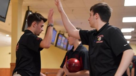 East Islip's Justin Orobello, left, is high-fived by