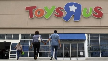 Shoppers walk into a Toys R Us store