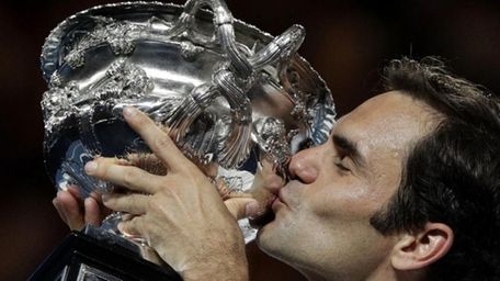 Switzerland's Roger Federer holds his trophy aloft after