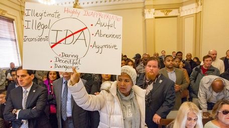 Jinette Frederique holds a sign at a Hempstead