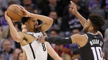 Nets guard Spencer Dinwiddie, left, holds the ball