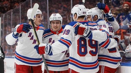 The Rangers celebrate a goal against the Oilers