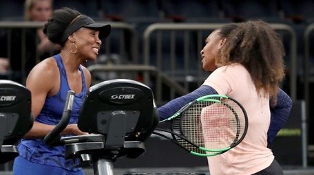 Venus Williams, left, and Serena Williams talk after