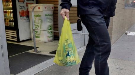 A man carries his purchase in a plastic